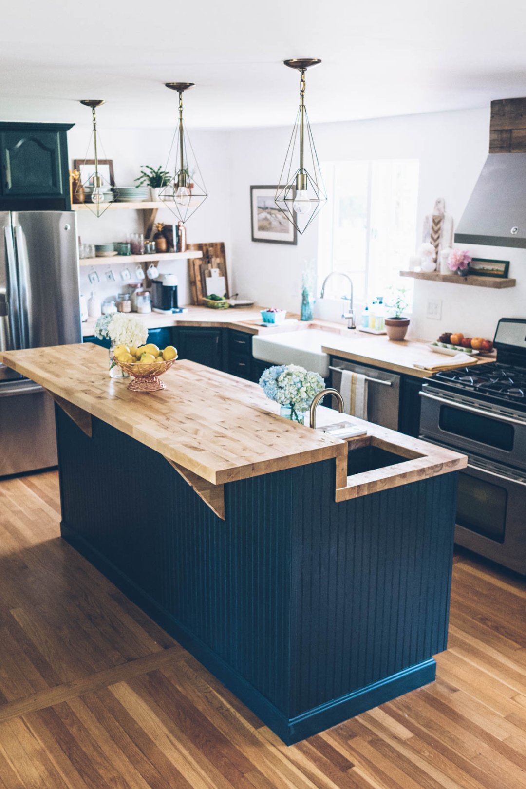 Jess Kirby's kitchen renovation features a new chalk painted island, brass pendant lights and butcher block counter tops