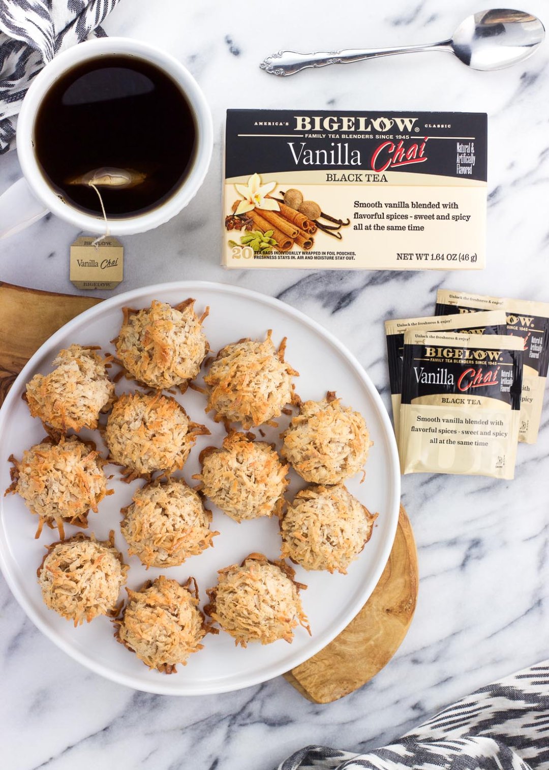 An image of a plate of macaroons, a box of Bigelow Vanilla Chai Tea and multiple individually-wrapped tea bags