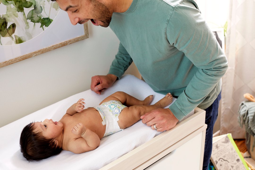 baby on changing table interacting with caregiver