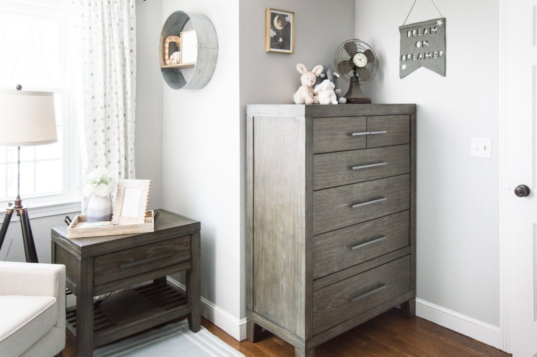 Classic baby boy nursery with rustic touches like this wooden dresser and end table
