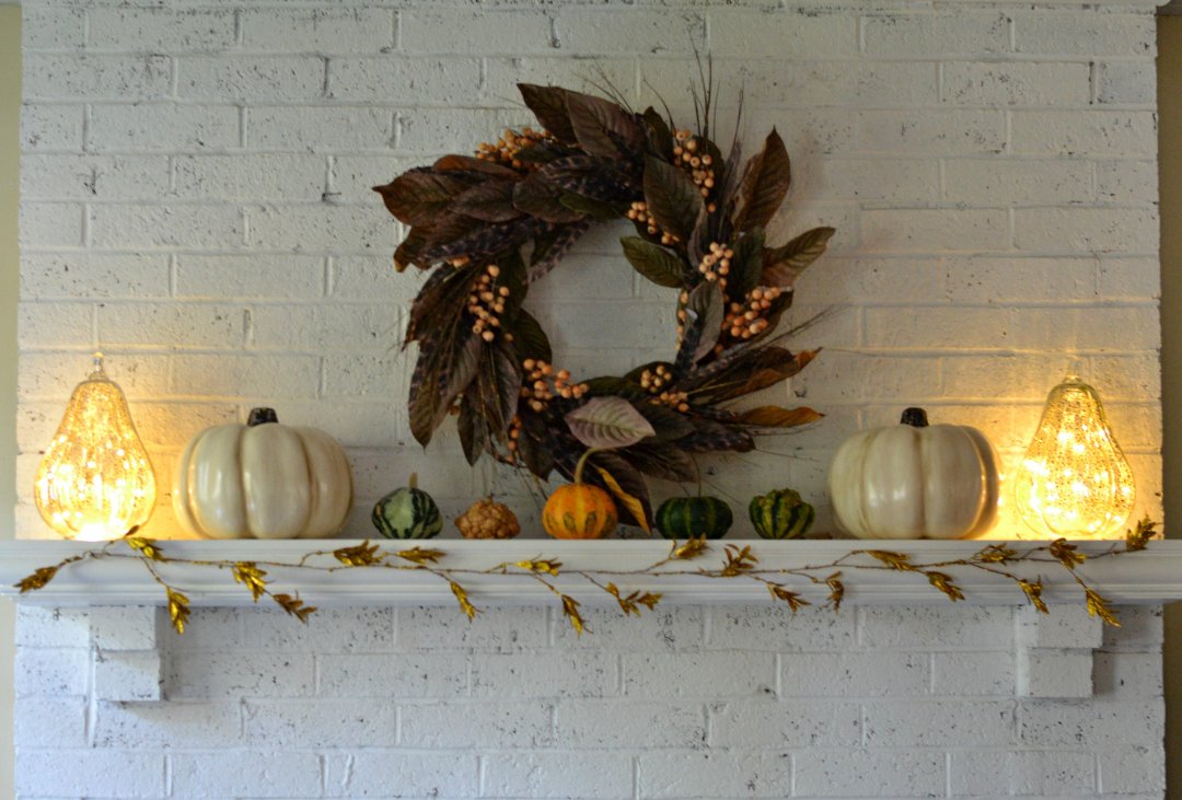 fall leaf wreath on a white mantle with white pumpkins and small pumpkins